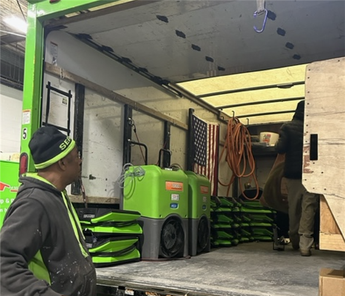 Employee loading equipment into a SERVPRO van.